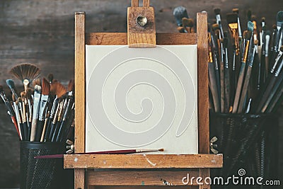 Artistic equipment in a artist studio: empty artist canvas and brushes. Stock Photo