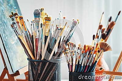 Artistic equipment in studio: painting, easel, paintbrushes and paints. Stock Photo