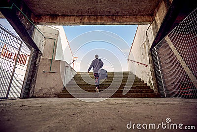 Artistic image composition of female in sportswear with a bag on her shoulder, going up the stairs. copy space Stock Photo