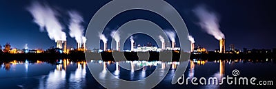 Industrial landscape with smoking chimneys and reflection in water at night Stock Photo