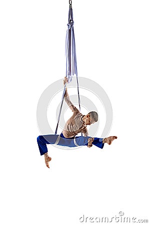Artistic performance. Young man, acrobat training with aerial ribbons, doing gymnastics tricks against white studio Stock Photo