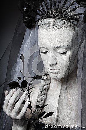 Artistic portrait of a girl covered in cracked white paint. Halloween makeup Stock Photo
