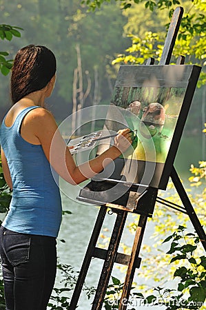 Artistic woman painting acrylic on canvas outside Stock Photo