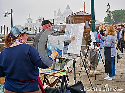 Artists painting in St Mark`s Square in Venice, Italy, on a misty, overcast day Editorial Stock Photo