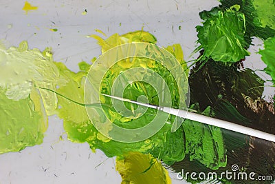 artists white brush and green acrylic oil paints on artistic palette. Stock Photo