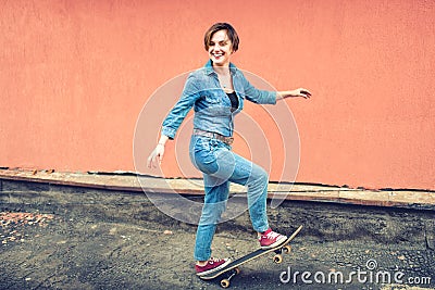 Artsy portrait of a brunette cute girl on a skateboard, laughing and having a good time. Healthy concept of modern life, hipster Stock Photo