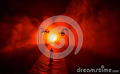 The silhouette of a man in shorts, standing in the middle of the road on a misty night. The glare of the street light against the Stock Photo