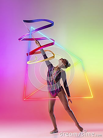 Creative artwork of prfessional female rhythmic gymnast in motion with bright ribbon over neon geometric element Stock Photo