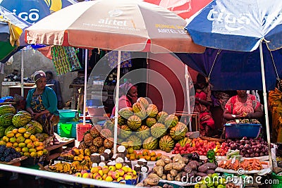 Arusha, Tanzania; 08/06/2019: Fruit stand with colorful parasol in a market of Arusha, Tanzania Editorial Stock Photo