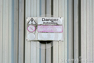 Asbestos danger sign on old galvanised shed wall. Stock Photo