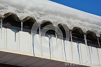 Asbestos house roof covered snow with icicles Stock Photo