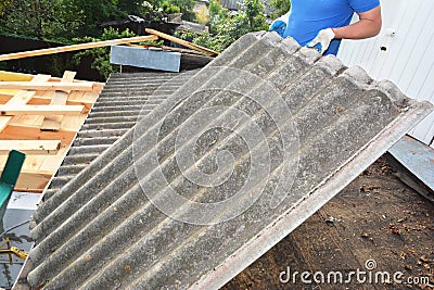 Asbestos removal roofer roof works. House with old, danger asbestos roof tiles repair and renovation. Risks of Asbestos Roofs, Stock Photo