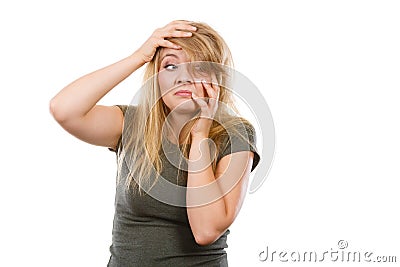 Ashamed embarrassed blonde woman with hands on face Stock Photo