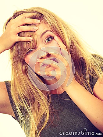 Ashamed embarrassed blonde woman with hands on face Stock Photo