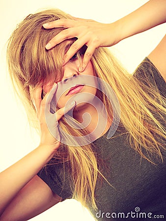 Ashamed embarrassed blonde woman with hands on face Stock Photo