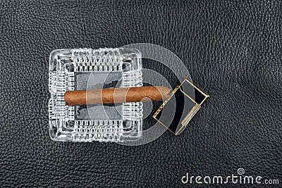 Ashtray, cigar and lighter lie on black natural leather Stock Photo