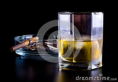 Ashtray full of butts and glass of whiskey Stock Photo