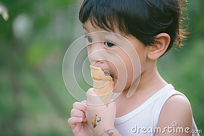 Asia boy he mouth aftertaste from eating chocolate ice cream or chocolate dessert. A sweet-toothed child eat chocolate. Kid with Stock Photo