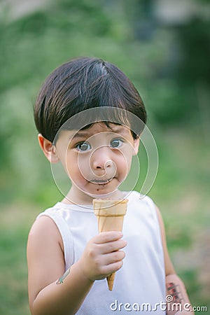 Asia boy he mouth aftertaste from eating chocolate ice cream or chocolate dessert. A sweet-toothed child eat chocolate. Kid with Stock Photo