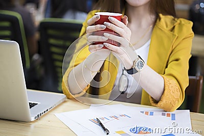 Asia businesswoman in office holding the red cup of coffee Stock Photo