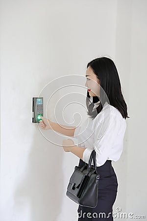 Asia Chinese office lady woman girl at work smile punch in out time clock fingerprint wear business occupation suit workplace Stock Photo