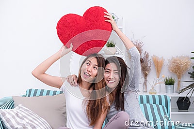 Asia lesbian lgbt couple holding red heart pillow together over Stock Photo