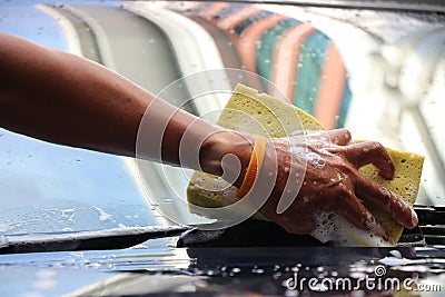 Asia male`s hand holding sponge with foams washing on windscreen by himself Stock Photo