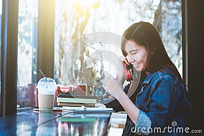 Asia teenage sitting alone using red telephone with smiling Stock Photo