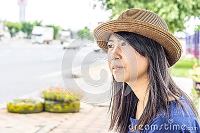 Asia thai girl sit on the bus stop wating car Stock Photo