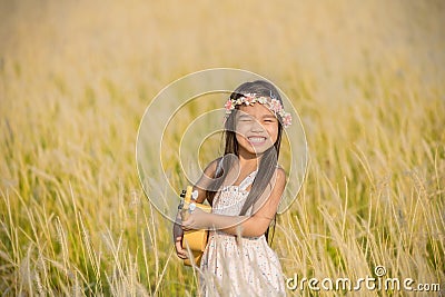 Asiagirl playing guitar to meadow outdoor in nature Stock Photo