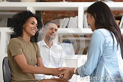 Asian and african women holding hands during group therapy session Stock Photo
