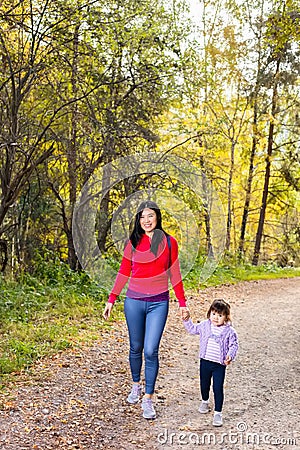 Asian appearance mother walking with her child in warm sunny autumn day Stock Photo