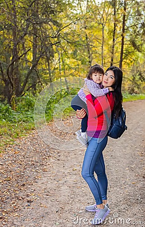 Asian appearance mother walking with her child in warm sunny autumn day Stock Photo