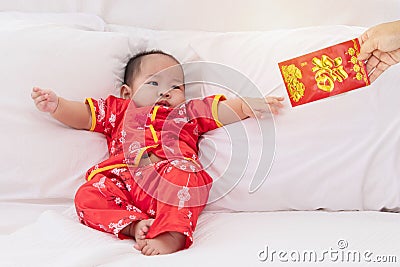 Asian baby boy Chinese Cheongsam costume toddler lie down on bed at home smiling laughing good humored infant Chinese boy laugh Stock Photo