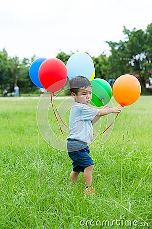 Asian baby boy play with bunch of balloon Stock Photo