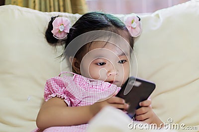 Asian baby girl looking at smart phone Stock Photo