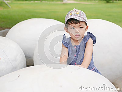 Asian baby girl touching a dinosaur egg to explore if she feels anything inside Stock Photo