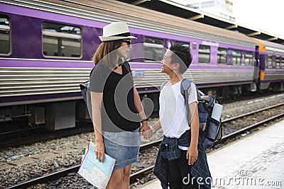 Asian backpack traveler woman with her son on platform at a train station Stock Photo