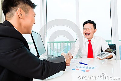 Asian banker advising on financial investment Stock Photo