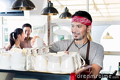 Asian barista preparing espresso for customer couple Stock Photo