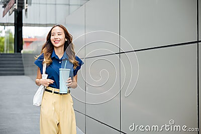 Business woman confident smiling with cloth bag holding steel thermos tumbler mug water glass Stock Photo