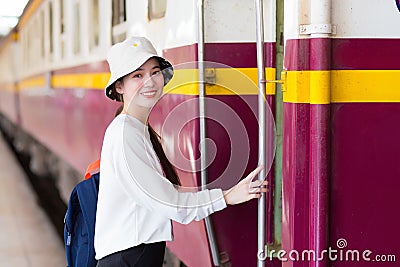 Asian beautiful girl was walking onto the train to travel while the train was parked at the platform Stock Photo