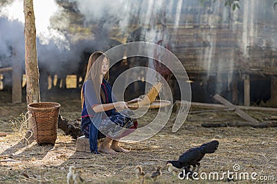 Asian beautiful girl winnowing rice separate between rice and rice husk Stock Photo