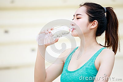 Asian beautiful sportswoman feel thirsty and drinking mineral water Stock Photo