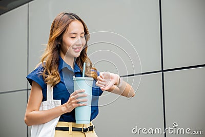 Business woman confident smiling with cloth bag holding steel thermos tumbler mug water glass Stock Photo
