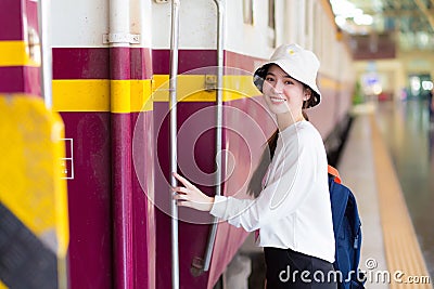 Asian beautiful woman was walking onto the train to travel while the train was parked at the platform Stock Photo