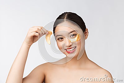 Asian beauty teenager woman care her skin with gold eye masks patches under eyes Stock Photo