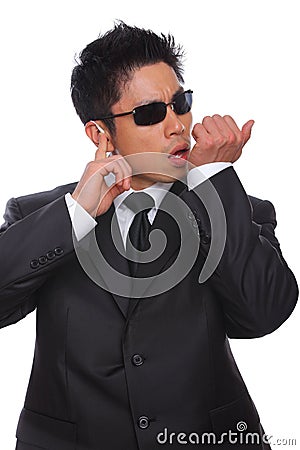 Asian Bodyguard talking in microphone listening Stock Photo