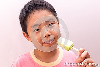 Asian boy eating a colorful frozen popsicle in the summer Stock Photo