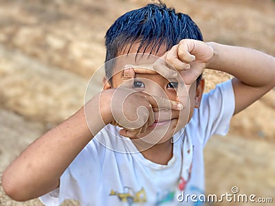 Asian boy with imaginary hand camera gesture pretending taking photo with outdoor background. Stock Photo